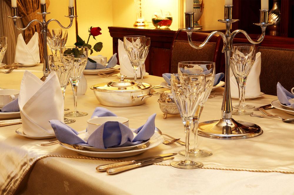 다르 알 이만 인터컨티넨탈 호텔 메디나 외부 사진 The image shows a beautifully arranged dining table set for a formal occasion. The table is covered with a light-colored tablecloth, and the place settings include elegant dinnerware, including plates and crystal glassware. 

Each place setting has f